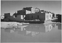 Acoma Pueblo and its reflection in a pool of water