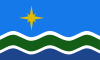 Flag comprising gold star on a light blue field with white, green, and dark blue waves below