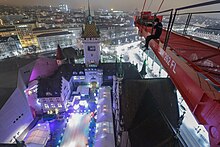 A rooftopper on a crane over the swiss national museum in winter at the time of the christmas event.