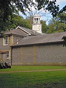 The stable block at Sheringham Hall with its cupola bell turret faced with a clock.