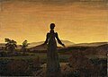 Ölgemälde von einer Frau, die dem Betrachter den Rücken zuwendet und mit leicht ausgestreckten Armen den Sonnenuntergang beobachtet. Der gelb-orange Himmel mit den Sonnenstrahlen ist das Zentrum des Bildes. Als Kontrast steht die Frau in schwarzem Kleid und mit Hochsteckfrisur. Die Landschaft mit Hügeln und Wiesen ist dunkel gehalten.