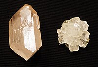 Crystallized sugar. Crystals on the right were grown from a sugar cube, while the left from a single seed crystal taken from the right. Red dye was added to the solution when growing the larger crystal, but, insoluble with the solid sugar, all but small traces were forced to precipitate out as it grew.