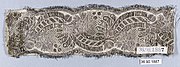 A length of wide, dark silver lace, featuring scrolls