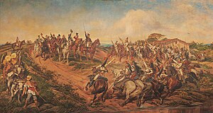 painting depicting a group of uniformed men on horseback riding towards a smaller group of mounted men who have halted at the top of a small hill with the uniformed man at the front of the smaller group raising a sword high into the air