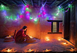 Sister lighting traditional lamp during Tihar festival (edited)