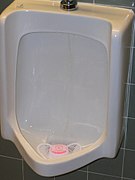 Urinal with pink-colored urinal cake
