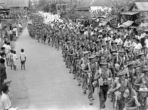 Soldiers of the Australian 2/31st Battalion passing through the town of Bandjermasin in Borneo as they took responsibility for the area from the Japanese on 17 September 1945