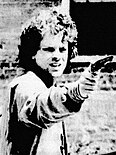 Black and white photo of a man aiming a pistol.