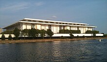 The Kennedy Center (a low-rise white building) as seen from the Potomac River