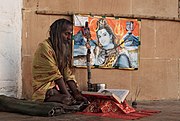 A Sadhu and a picture of Siva in Kayasth Tola, Varanasi, Uttar Pradesh in Northern India