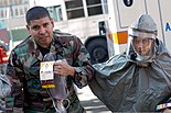U.S. Air Force Capt. Jennilyn Estell, right, a dentist with the 374th Dental Squadron, guides Senior Airman Fausto Rojas, a simulated patient with the 374th Medical Support Squadron, to a decontamination area