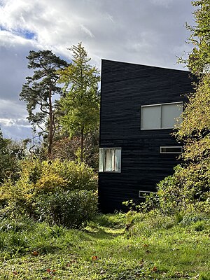 Modernist architectural structure amidst woodland.
