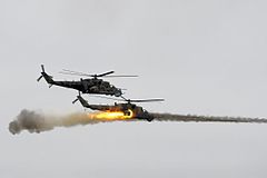 Zwei russische Mi-24, davon einer beim Abfeuern von ungelenkten Luft-Boden-Raketen