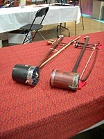 Two tro saus with cylinder soundboxes. The instrument on the right has a snakeskin head.