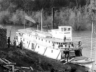 Mascot, a typical wooden-hulled sternwheeler, "wooding up", circa 1900