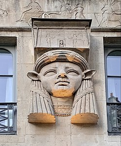 Egyptian Revival mascaron with the face of goddess Hathor on the facade of the Foire du Caire building (Place du Caire no. 2), Paris, by Philippe-Laurent Prétrel, 1798[40]