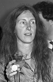 Eva Quistorp ist auf einer schwarz-weiß Fotografie abgebildet. Sie hält ein Cocktailglas in der Hand und hat sehr langes offenes Haar. Sie schaut nicht in die Kamera.