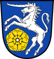 Gemeinde Rugendorf In Blau ein steigendes silbernes Einhorn, rechts unten eine goldene heraldische Rose mit silbernen Kelchblättern.