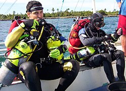 Divers preparing for a decompression dive using backplate and wing with sling mounted decompression gas cylinders.