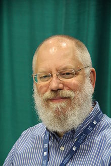 head shot of bearded poet with rimless glasses and buttoned down shirt