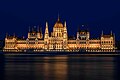 Exterior view of the Hungarian Parliament at night seen from the banks of the Danube river