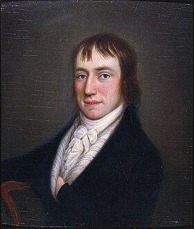 Half length portrait of rosy-cheeked man in his late twenties, sitting in black coat and white high-necked ruffled shirt with his left hand in his coat. He has medium-length brown hair.