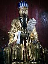 Statue of Zhuge Liang holding a feather fan inside a temple