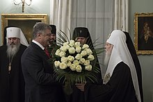 Filaret and Poroshenko, holding a bouquet of white roses