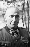 Black-and-white portrait of a man wearing a military uniform with an Iron Cross displayed at his neck.