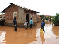 Boys standing in flood waters in residential area, Kampala, Uganda