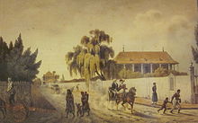 Painting of street scene depicting from left to right a man standing on a horse cart, a group of two women and two children in indigenous garments, a man and a woman seated in a buggy pulled by one horse, a person in a long coat standing on a corner, and two black figures walking around the corner. In the background are two trees and two houses
