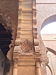 A palmette/seashell motif carved into the arches near the mihrab