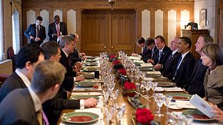 US President Barack Obama and Canadian Prime Minister Stephen Harper with aides during a working luncheon in the Canadian Parliament in Ottawa, Ontario, in 2009