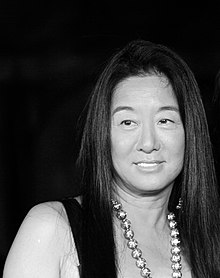 A black-and-white image of a woman with long black hair and necklace