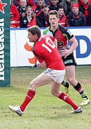 Ronan O'Gara playing for Munster and passing the ball to a teammate in 2013