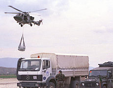 A helicopter arrives at a refugee facility in Macedonia with an underslung load of aid.