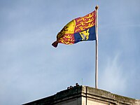 The flagpole on Buckingham Palace, London, here flying the Royal Standard, has a crown-shaped finial.