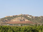 Photo shows a large hill crowned by old fortifications.