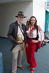 A photograph of a man and woman dressed as Indiana Jones and Marion Ravenwood respectively at a fan convention