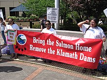 Klamath tribes members holding a banner that reads: Bring the Salmon Home / Remove the Klamath Dams