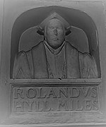Sir Rowland Hill bust in the school at Market Drayton: the variation in the spelling of his name is notable, as is the style of the monument which may show the approach of his lost funerary monument in London;. The style, which would become popular from the early to mid-17th century, was most commonly used to memorialize divines, academics, and those professions with pretensions of learning. it shows some resonance with the funerary monument of Shakespeare.