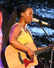 Zahara playing guitar and singing into a microphone