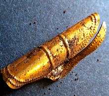 Colour photograph of a gold ornament discovered in one of the Kirkhaugh cairns