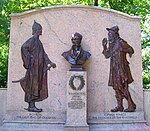 Bronze bust flanked by two male statues of Irving characters