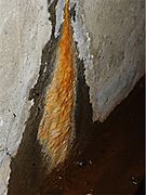 Calthemite flowstone on concrete wall.
