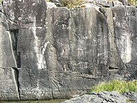 Petroglyphs in a dark rock wall