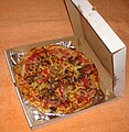 An open pizza box with a pizza inside