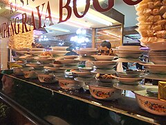 An array of Padang dishes arranged in a restaurant window.