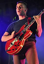 Man playing a red guitar