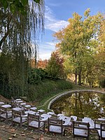 Art installation in the Dumbarton Oaks Garden showing school desks in front of the lake